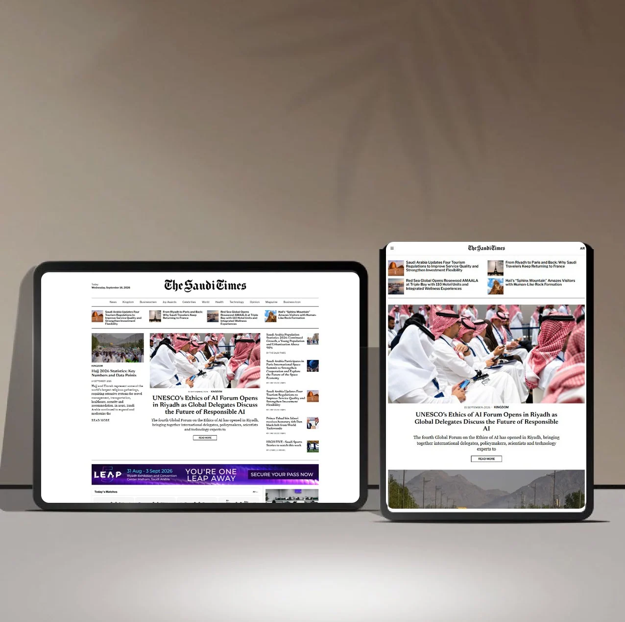 Two tablets on a shelf showing The Saudi Times website
