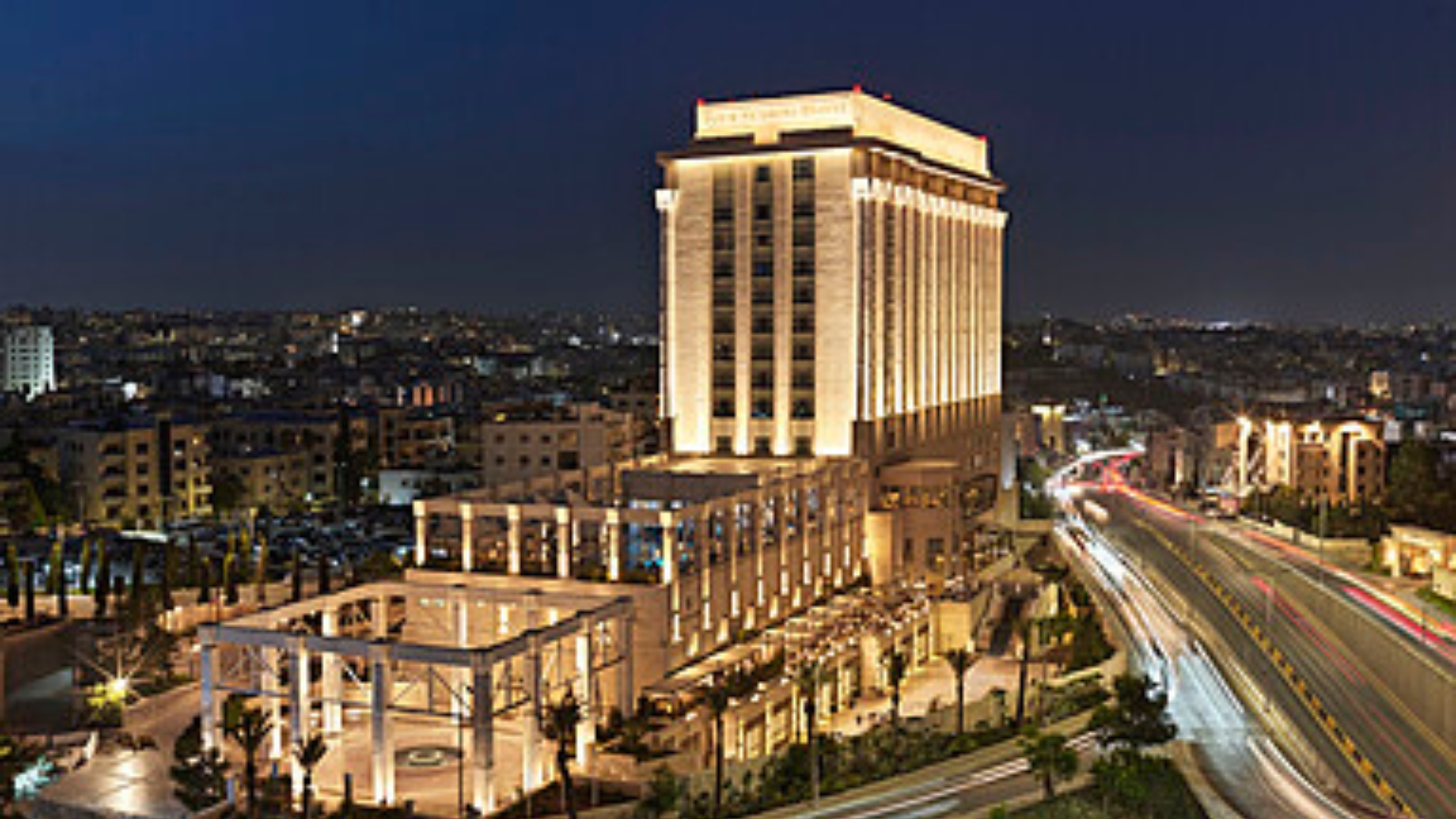 The Exterior Of Four Seasons Hotel Amman Rises Above The City, Offering A Luxury Stay In The Heart Of The Capital