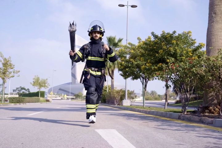 Saudi firefighter prepares for the 16th World Firefighter Games by running in Dharan heat in full uniform and gear.